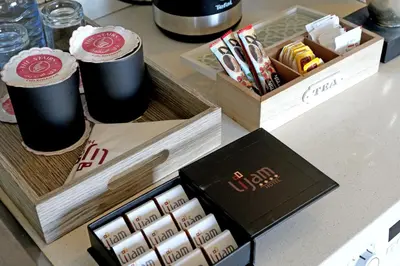 a counter with two cups of coffee and a box of food at Lijam Hotel in Amman