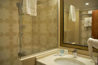 a bathroom with a sink and a shower with a mirror at Guest House Hotel Amman by FHM in Amman