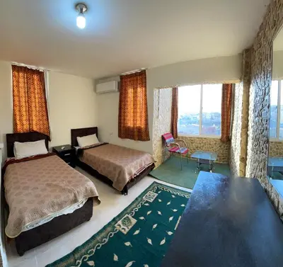 a hotel room with two beds and a table at Orient Gate in Wadi Musa