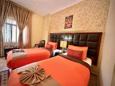 a hotel room with two beds with orange sheets at Anbat Midtown Hotel in Wadi Musa