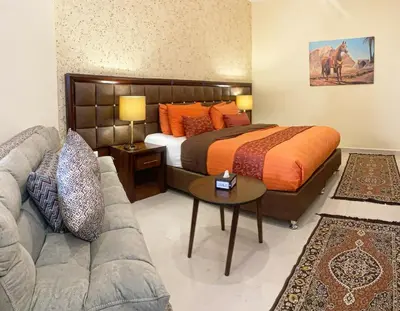 a bedroom with a bed and a couch at Anbat Midtown Hotel in Wadi Musa