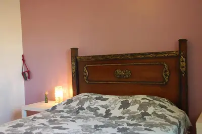 a bed with a wooden headboard in a bedroom at B&B Petra Fig Tree Villa in Wadi Musa