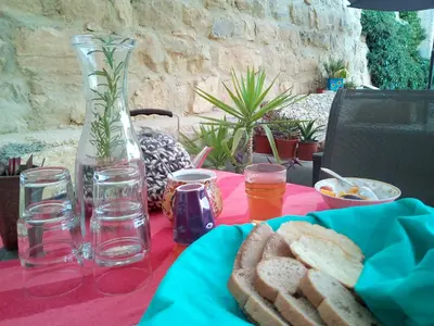 a table with a vase and a plate of bread at B&B Petra Fig Tree Villa in Wadi Musa