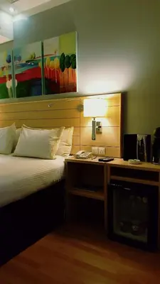 a bedroom with a bed and a desk with a lamp at Crystal Hotel in Amman