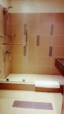 a bathroom with a shower and a bath tub at Crystal Hotel in Amman
