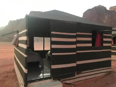 a black and white rv parked in the desert at Black Irish Camp And Tours in Wadi Rum