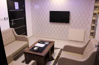a waiting room with two chairs and a tv on a wall at Virginia Hotel in Amman