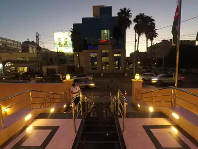 a man is riding a slide in a city at night at Virginia Hotel in Amman