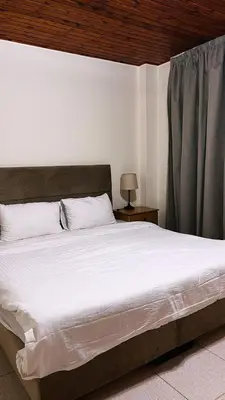 a bedroom with a large white bed with a window at Pilgrim's Guest House in Madaba