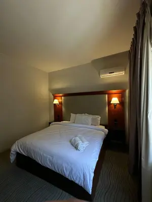 a hotel room with a large bed with white sheets at Amman Pasha Hotel in Amman