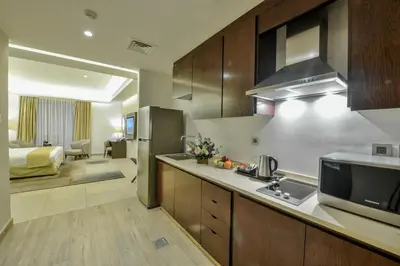 a large kitchen with a sink and a microwave at Downtown Hotel Apartments in Amman