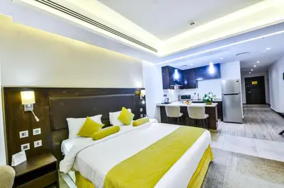 a hotel room with a large bed and a kitchen at Downtown Hotel Apartments in Amman