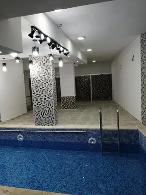 a large swimming pool in a building with a pool at Weekend Hotel in Aqaba