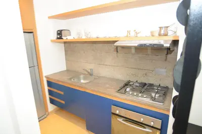 a small kitchen with a sink and a stove at Burda 41 Hotel & Suites in Amman