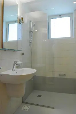 a white bathroom with a sink and a shower at Burda 41 Hotel & Suites in Amman