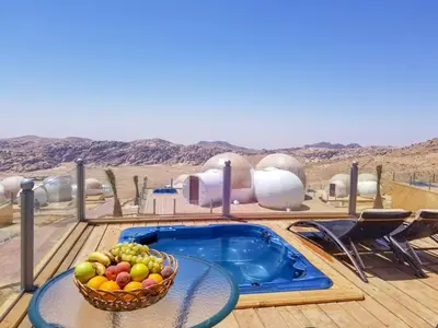 a bowl of fruit on a table next to a hot tub at Petra Bubble Luxotel in Wadi Musa