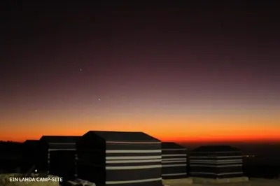 two tall buildings with the sunset in the background at Ein lahda camp-site in Dana