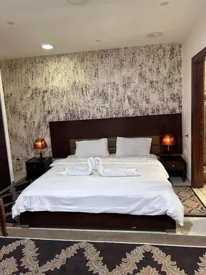a bedroom with a large bed with a white blanket at Robou Al Sharq in Amman
