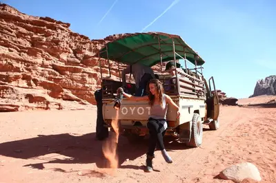 a woman sitting on the back of a vehicle in the desert at Bedouin Expedition in Wadi Rum
