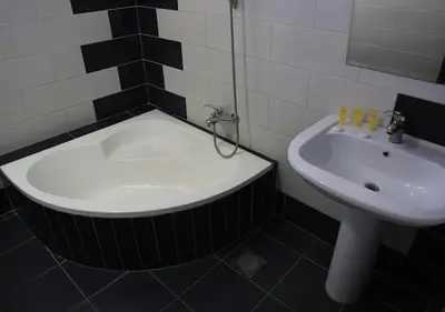 a bathroom with a bath tub and a sink at Ajnadeen Hotel in Irbid