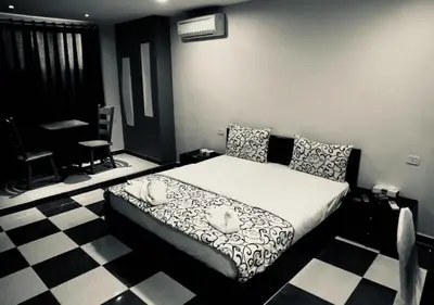 a bedroom with a bed and a checkered floor at Ajnadeen Hotel in Irbid
