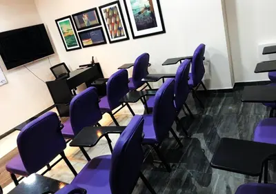 a room with purple chairs in a classroom at Ajnadeen Hotel in Irbid