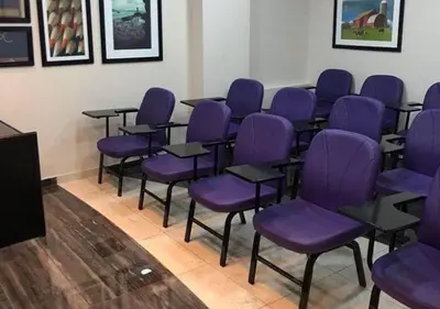 a conference room with purple chairs and a podium at Ajnadeen Hotel in Irbid