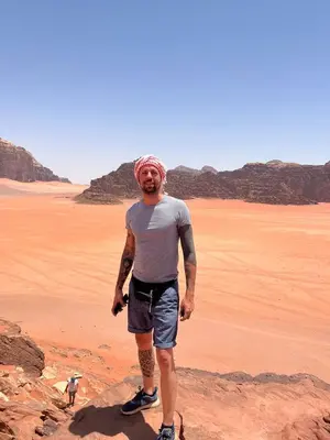 a man standing on a rock in the desert at Bedouin Holidays Camp and Jeep Tours in Wadi Rum