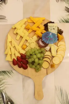 a plate of cheese and fruit on a cutting board at The SanRock Hotel in Amman