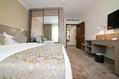 a hotel room with a large bed and a desk at The SanRock Hotel in Amman