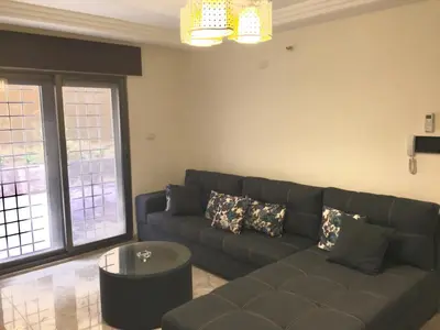 a living room with a couch and a table at Royal Luxury Apartments & Studios in Amman