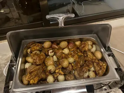 a pan filled with potatoes and meat in an oven at Petra Sky Hotel in Wadi Musa