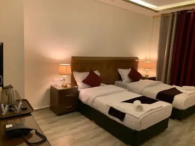 a hotel room with two beds and two lamps at Petra Sky Hotel in Wadi Musa