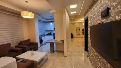 a living room with a large flat screen tv on a brick wall at Western Gate Residence 2 Amman in Amman