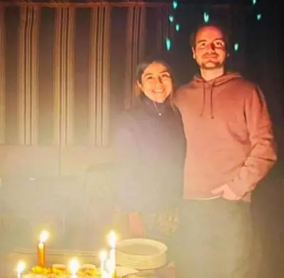 a man and a woman standing in front of a table with candles at Miral Night Camp in Wadi Rum