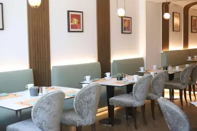 a dining room with tables and chairs in a restaurant at Hilton Amman in Amman
