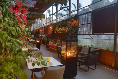 a restaurant with tables and chairs and flowers in a building at Hilton Amman in Amman