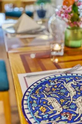 a wooden table with a blue plate on top of it at The Liwan Hotel in Amman
