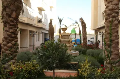 a garden with a statue in the middle of a building at Western Gate Residence 1 - Amman, Jordan in Amman