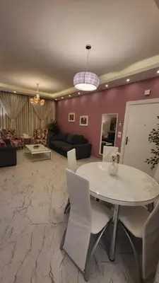 a living room with a white table and chairs at Western Gate Residence 1 - Amman, Jordan in Amman