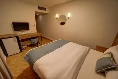 a hotel room with a bed and a television at Crystal Hotel By FHM in Aqaba
