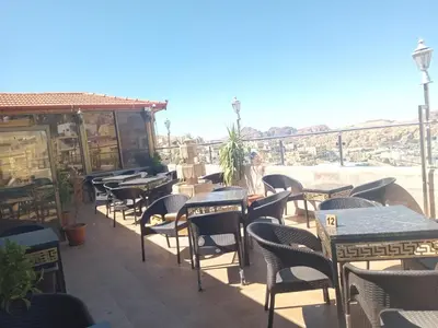 a row of tables and chairs on a patio at Petra Visitors Hotel in Wadi Musa