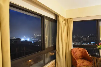 a room with a window with a chair and a view at Saray Hotel Amman in Amman