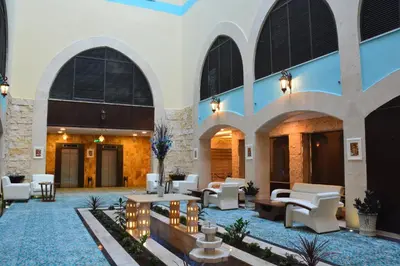 a lobby of a hotel with tables and chairs at Saray Hotel Amman in Amman