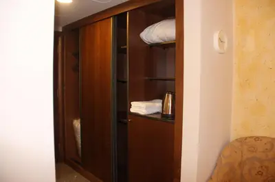 a closet with a wooden cabinet with towels in it at Saray Hotel Amman in Amman