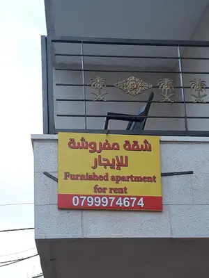 a sign on the side of a building at Furnished Apartments Near McDonald's Al-Madina Al-Monawara St in Amman