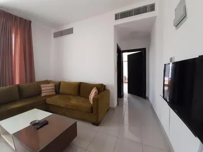 a living room with a couch and a flat screen tv at Furnished Apartments Near McDonald's Al-Madina Al-Monawara St in Amman