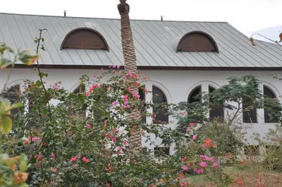 a house with pink flowers in front of it at Russian Pilgrim Residence in Sowayma