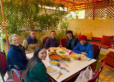 a group of people sitting around a table eating food at Al-Amer Hostel 1 in Aqaba