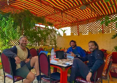a group of three men sitting at a table at Al-Amer Hostel 1 in Aqaba